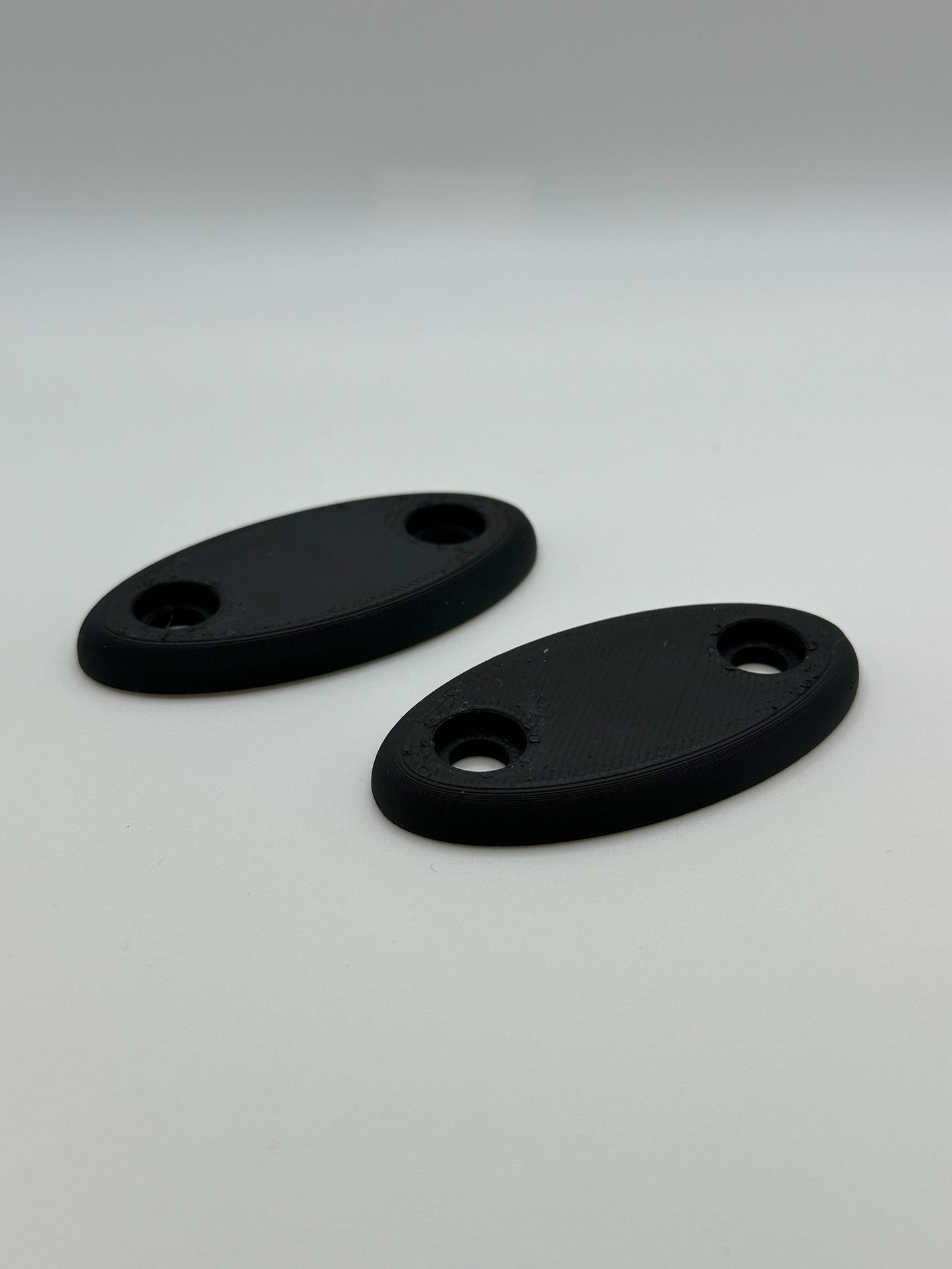 Set van twee zwarte ovale plaatjes, 3D-geprint voor veelzijdig gebruik.